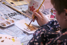 A visitor tries out some art supplies at one of our creative craft shows.